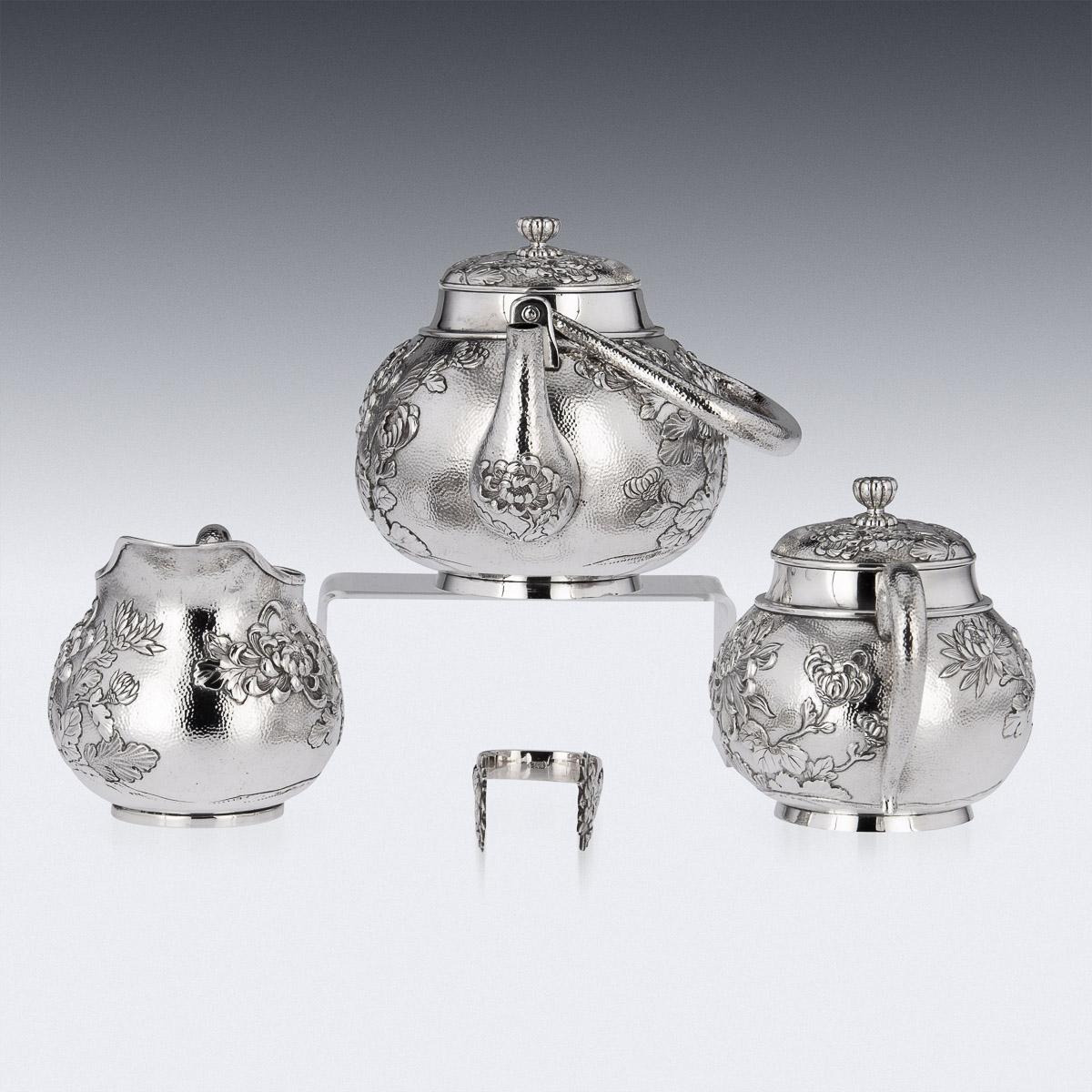 20th Century Japanese silver four piece tea set, consisting of a teapot, sugar bowl, lidded cream jug and sugar tongs, exceptional quality, double walled, embossed with with chrysanthemums and foliage in high relief on matted ground, C-form handles,