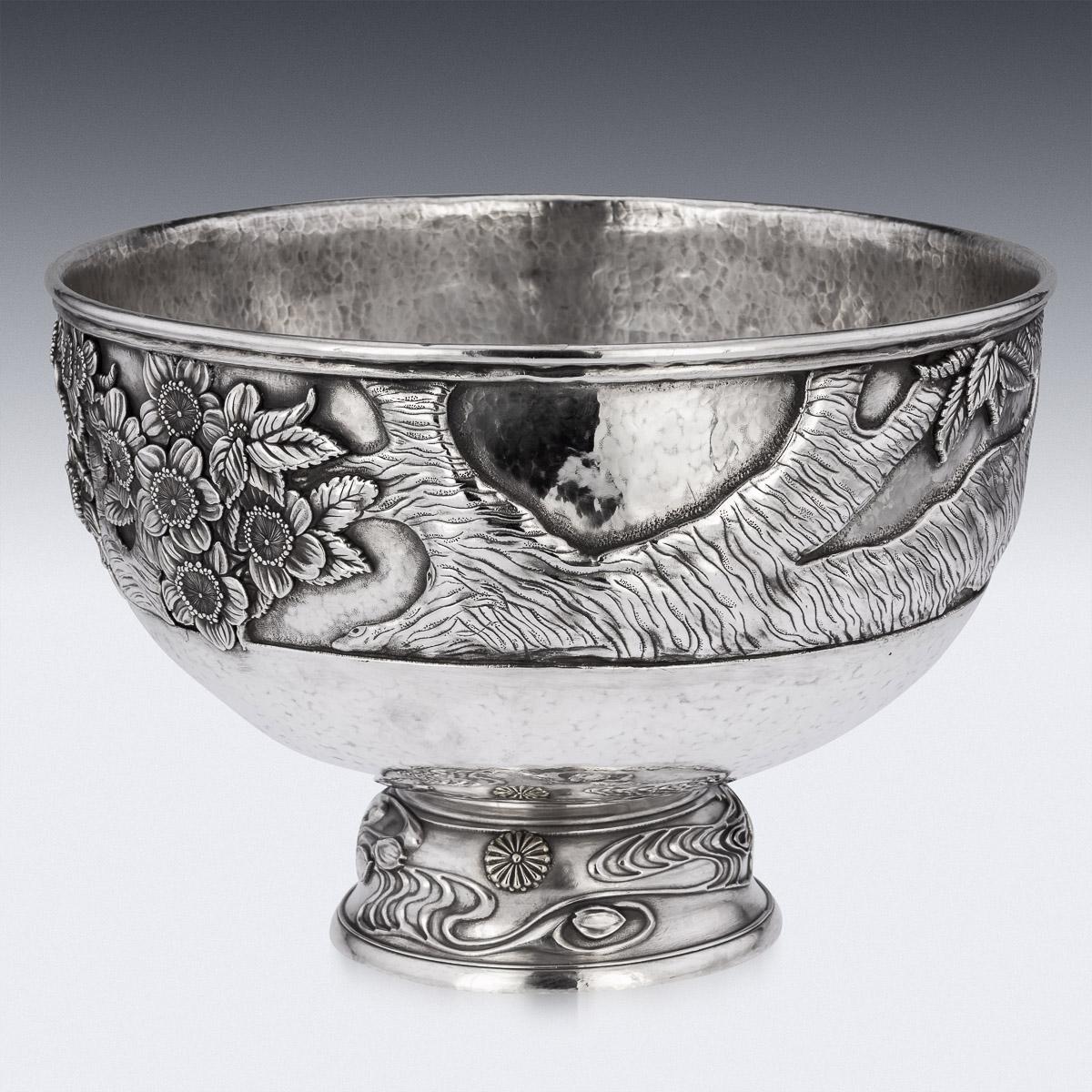 19th Century Japanese Meiji period monumental silver bowl, exceptional and magnificent quality, embossed with a continuous landscape and large cherry tree and blossom in high relief on matted hand hammered ground. Standing on a domed base, decorated