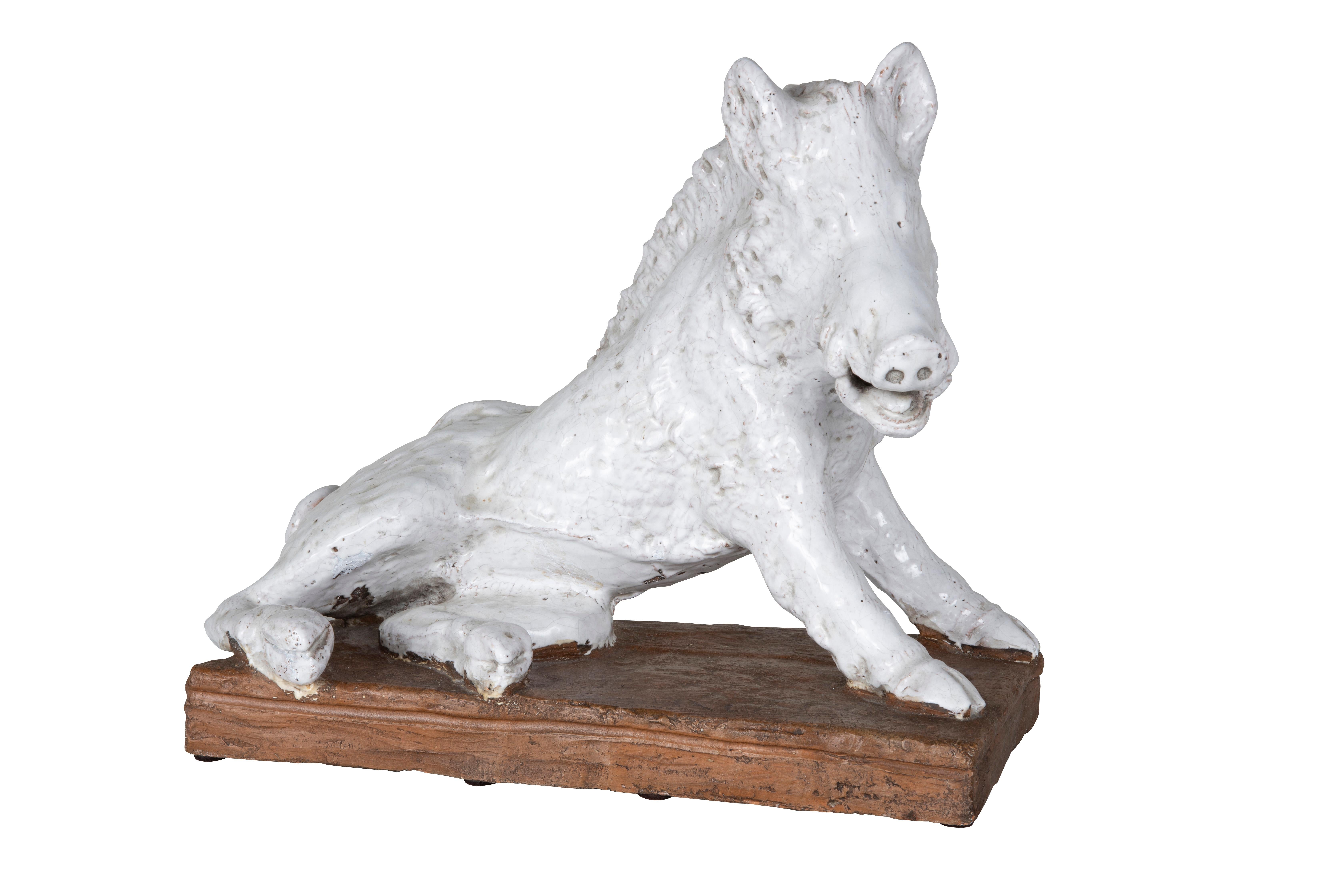 This monumental white raku ceramic boar sits upon a rust-colored base. Hand-molded in 20th Century and sourced from Italy. Raku is a Japanese ceramic art form. The pottery pieces are fired at low temperatures and then rapidly cooled. 

The Inoshishi