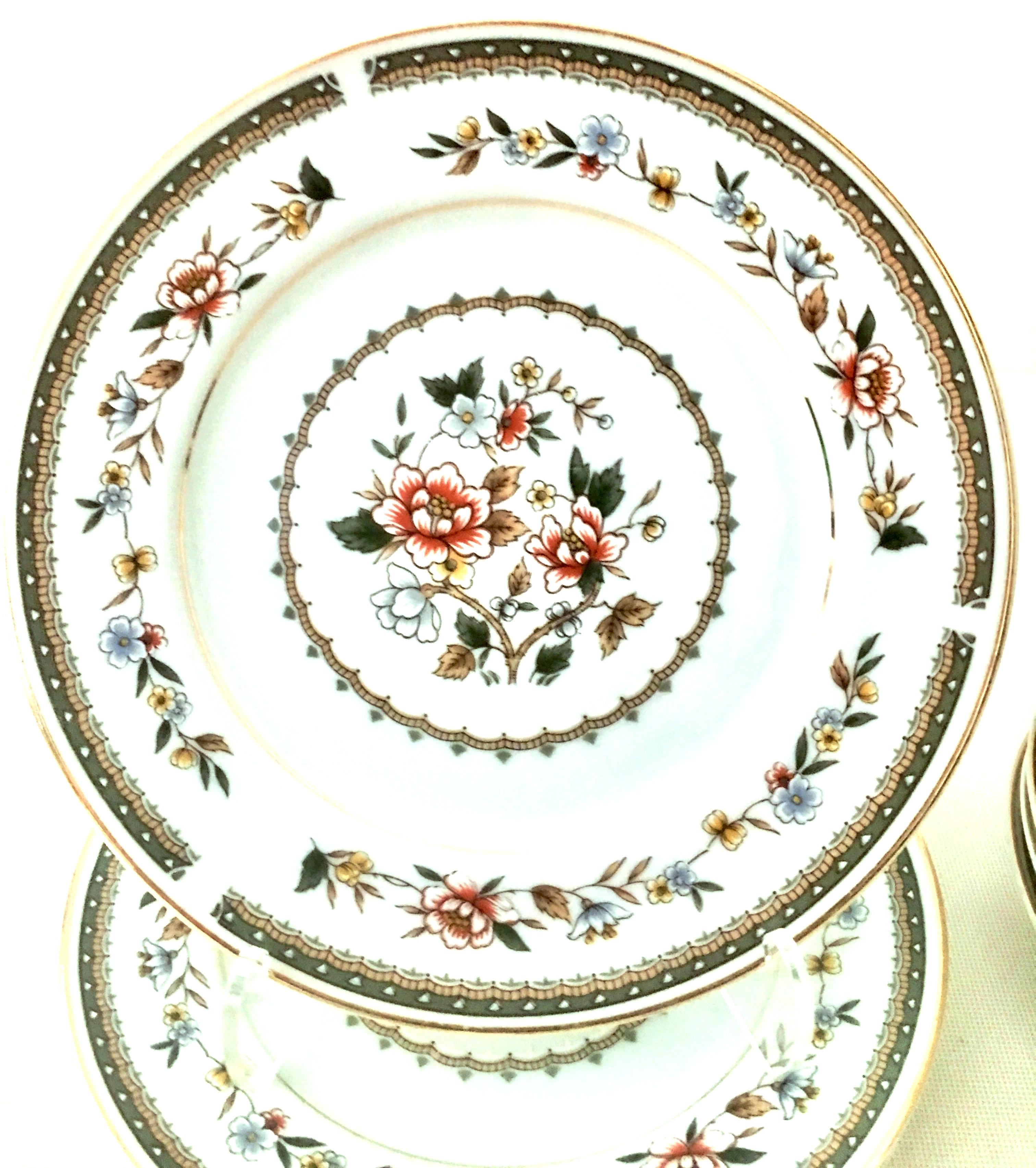 1960's Japanese Porcelain & 22K gold floral motif dinnerware S/13. Set features a bright white ground with 22-karat gold rim and center trim. A scattered floral pattern in khaki, rust, blue, green and yellow. Classic and timeless each piece is