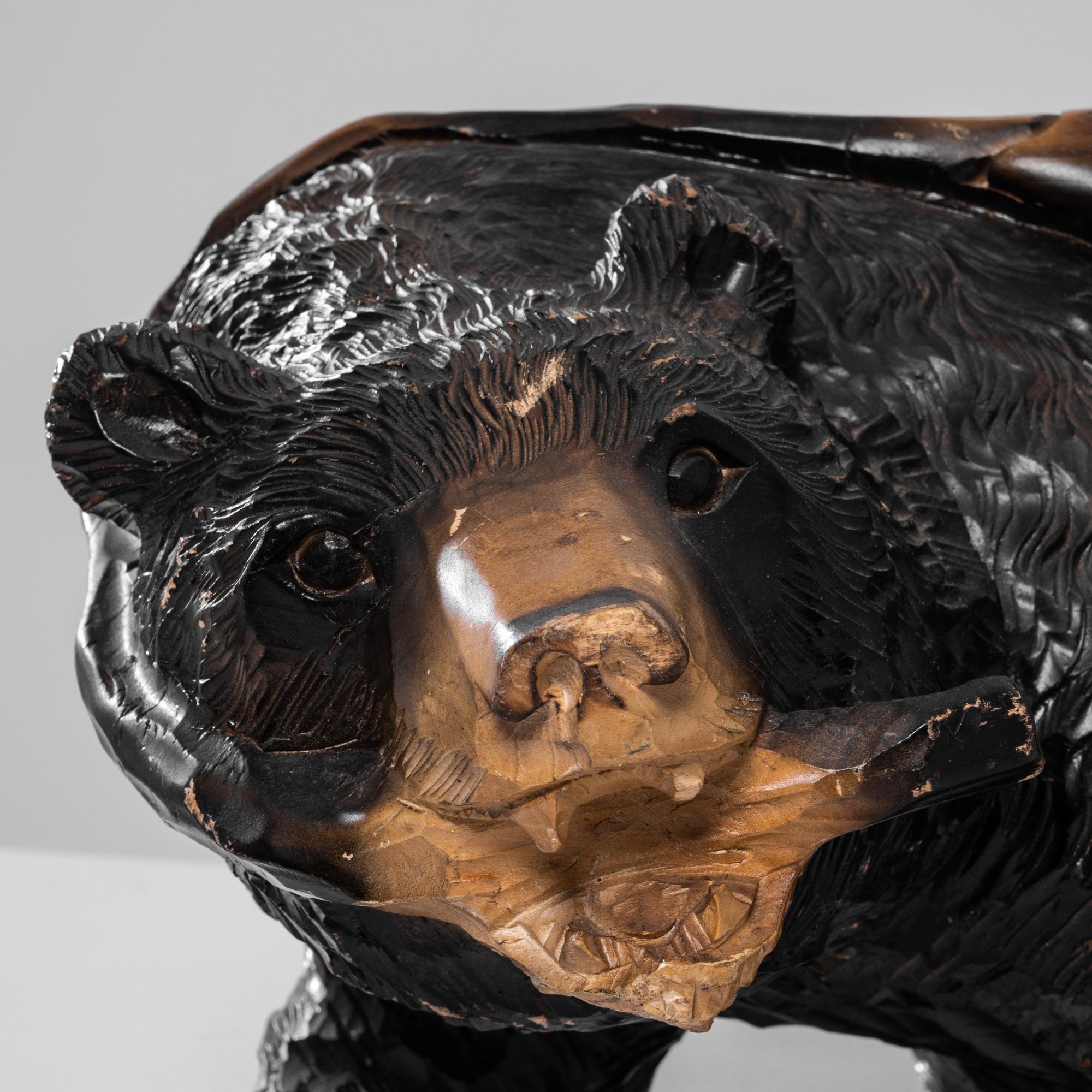 This exquisite 20th-century Japanese wooden bear sculpture captures the essence of traditional craftsmanship and nature's raw beauty. Hand-carved from rich, dark wood, the bear's lifelike posture and detailed fur texture exhibit remarkable artistry.