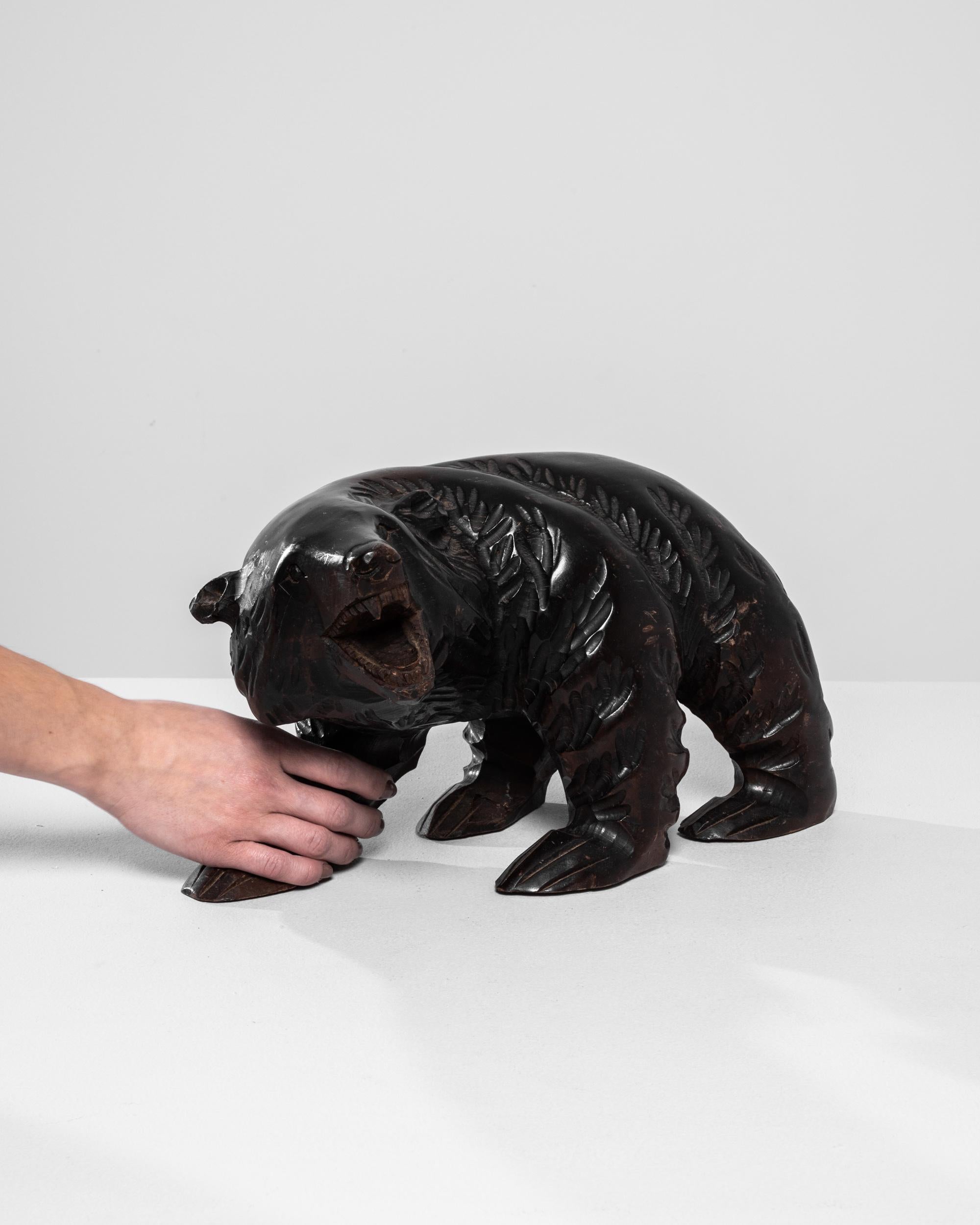 This captivating 20th-century Japanese wooden bear sculpture exemplifies exceptional craftsmanship and attention to detail. Carved from rich, dark wood, this piece features a majestic bear in a dynamic stance, its mouth open in a lifelike roar. The