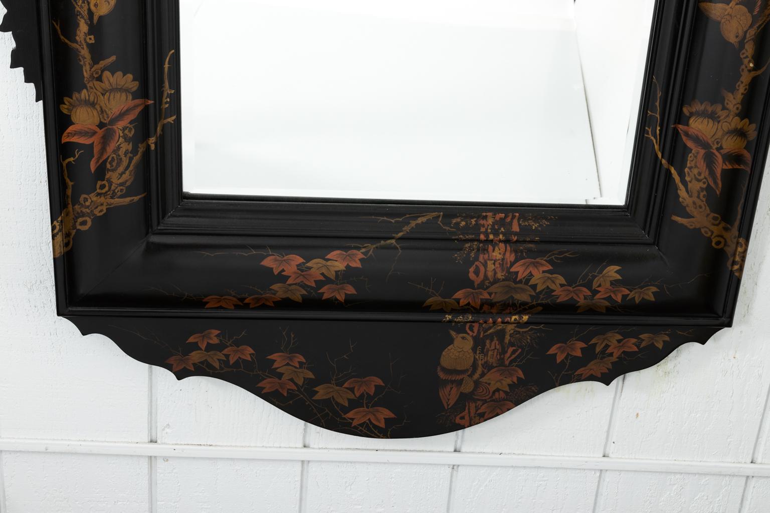 Japanned mirror with foliage and birds painted on an ebonized wooden frame with scalloped pediment, circa 20th century.