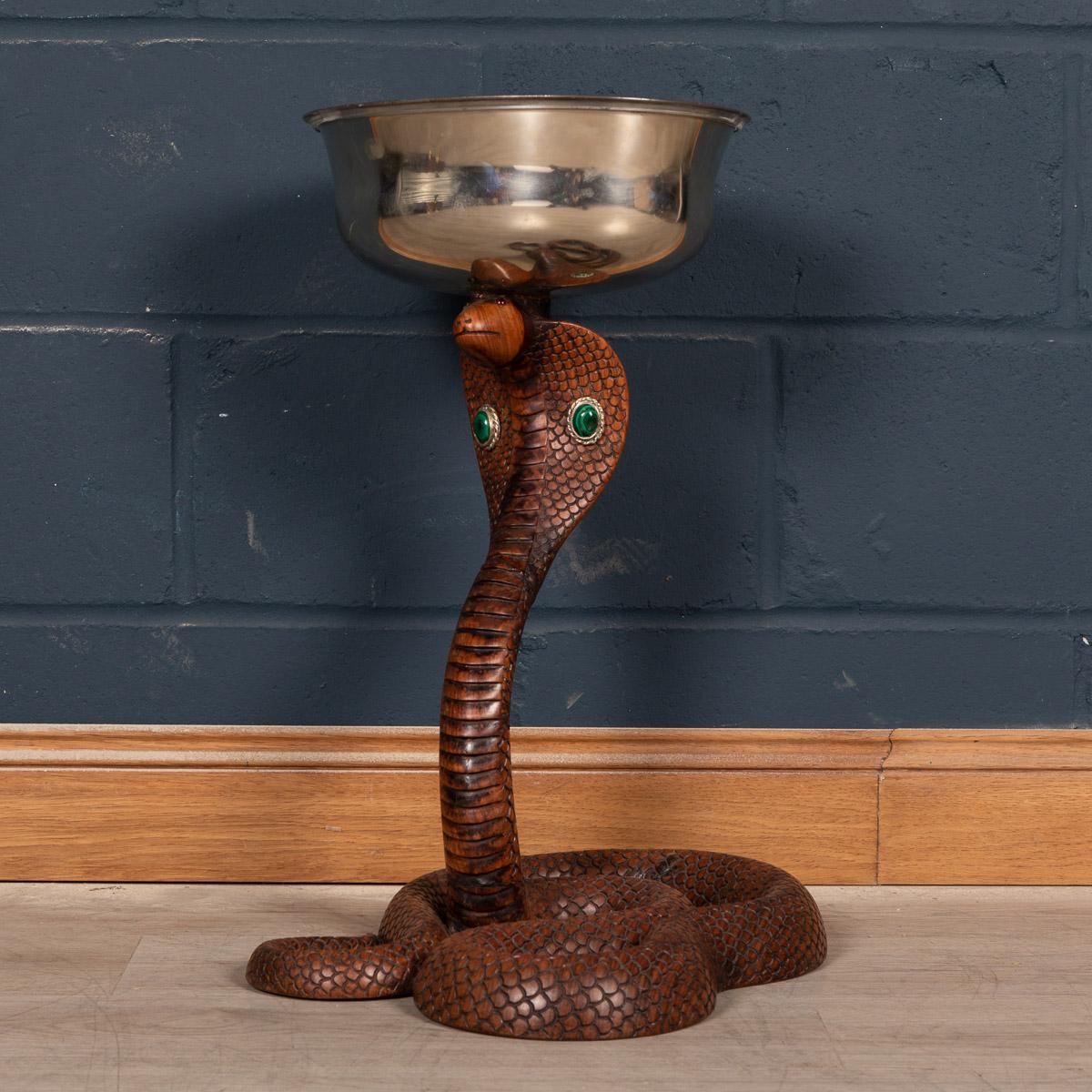 An extremely rare jardiniere or wine cooler by Anthony Redmile, with a plated metal salver cover top, supported on a carved wooden cobra, with malachite and silvered metal cabochons to the head.

Anthony Redmile burst into the London interior