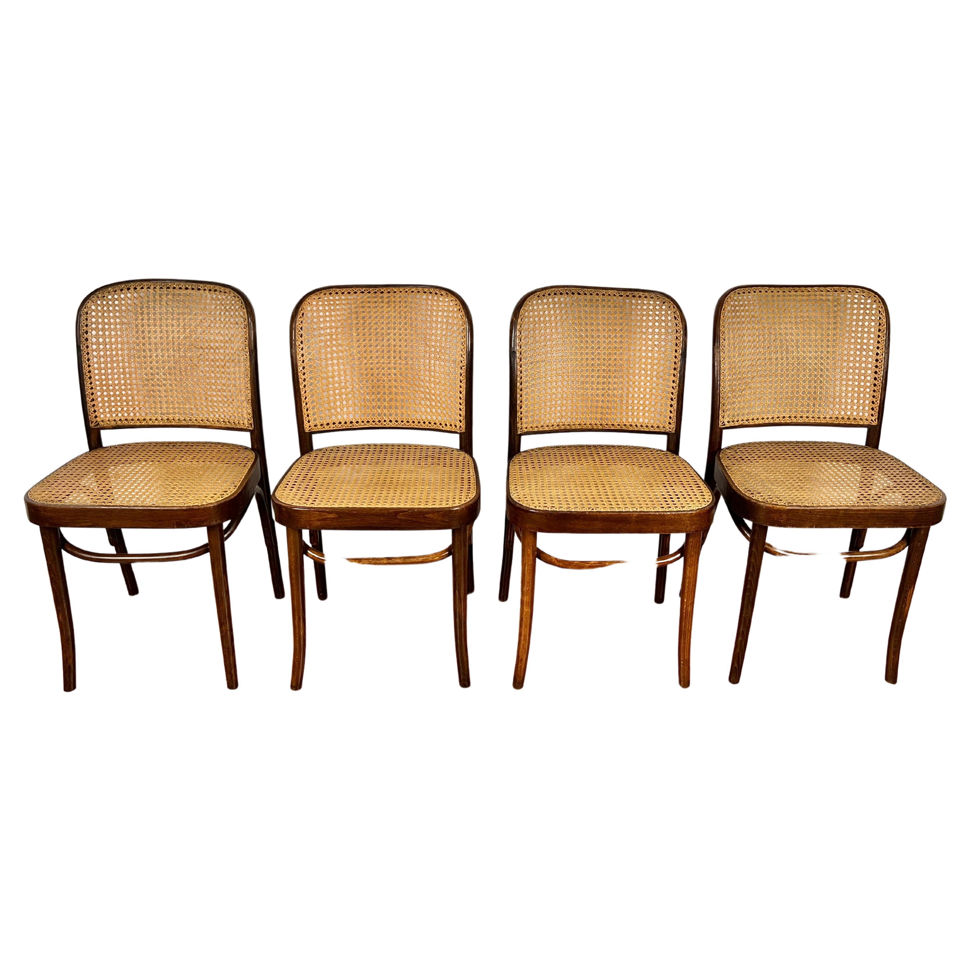 This lovely early set of Prague chairs designed by Josef Hoffmann were produced in Poland by FMG. Each chair retains an original hand caned seat and back and the manufacturer's paper labels and stamps as well. The finish has age appropriate wear and