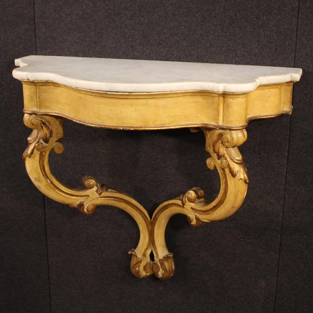 Italian console from the first half of the 20th century. Furniture to hang on the wall in carved, lacquered and gilded wood of beautiful decoration. Top in marble of good size and service. Console without drawers, ideal for displaying objects or