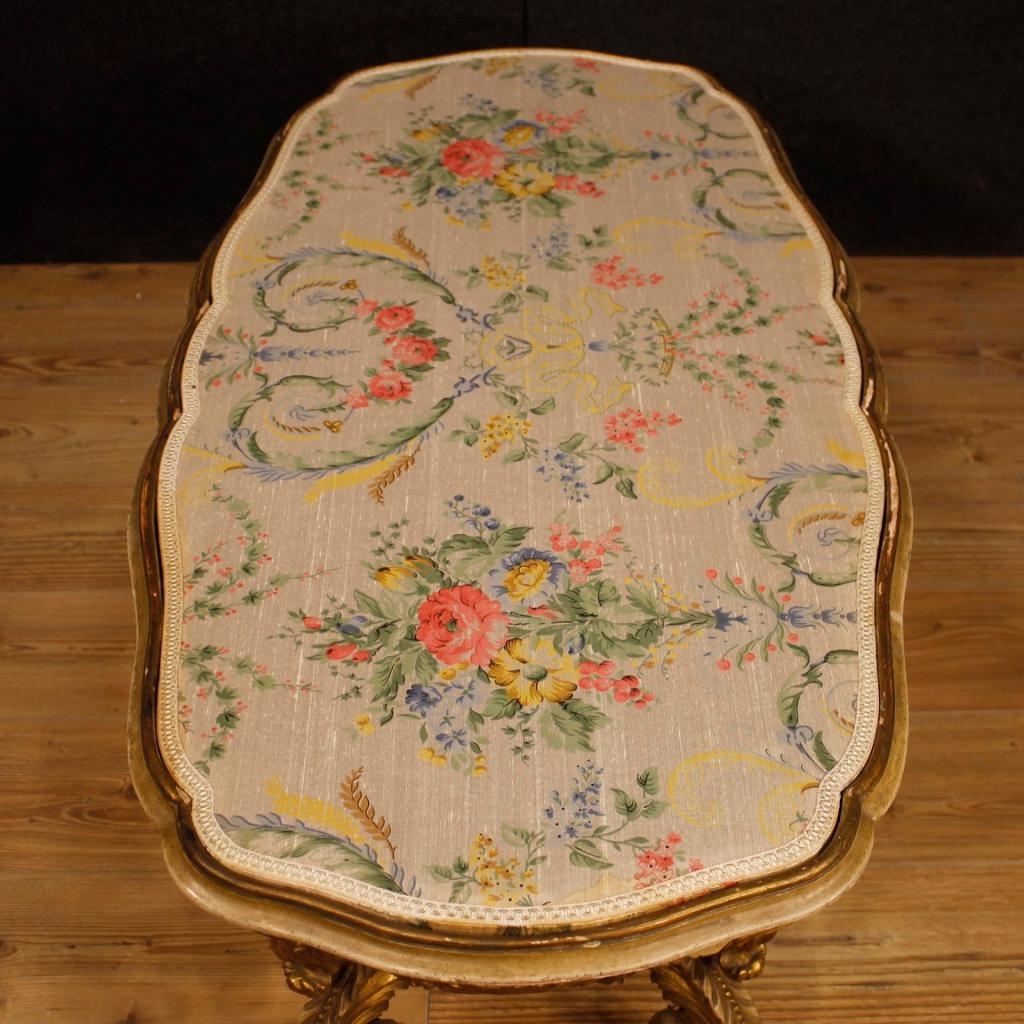 Italian coffee table from 20th century. Furniture in richly carved, lacquered and gilded wood of high quality. Top covered in floral fabric with some stains (see photo), of good measure and service. Coffee table of pleasant decor with some small