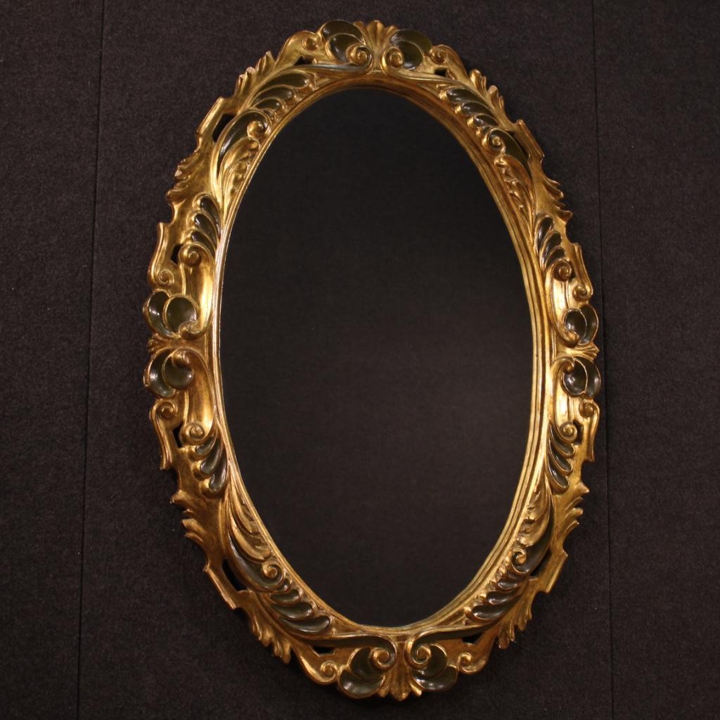 Italian oval mirror from 20th century. Furniture in wood and plaster richly carved, lacquered and gilded of excellent quality. Mirror can be positioned both horizontally and vertically thanks to the two special rear hooks. Furniture of beautiful