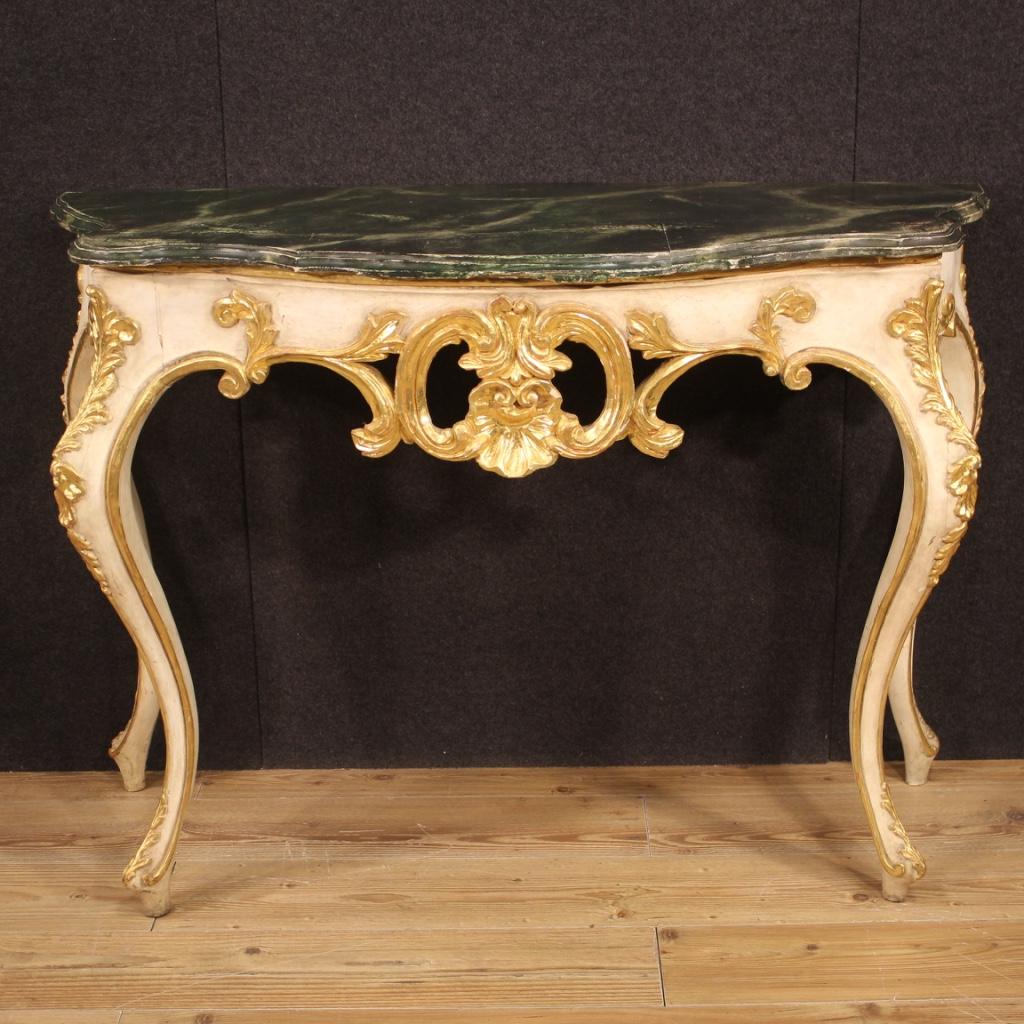 Italian console from 20th century. Furniture in carved, lacquered and gilded wood of excellent quality and fabulous furnishings. Wall console supported by four wavy legs, also lacquered and gilded, of good solidity. Wooden top in character (faux
