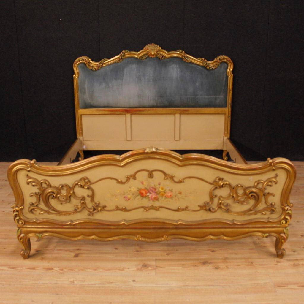 20th century Italian double bed. Furniture in richly carved, lacquered and gilded wood with floral decorations, of great impact. Fabulous furnishings bed, headboard with velvet panel with some signs of wear (see photo). Footboard decorated with hand