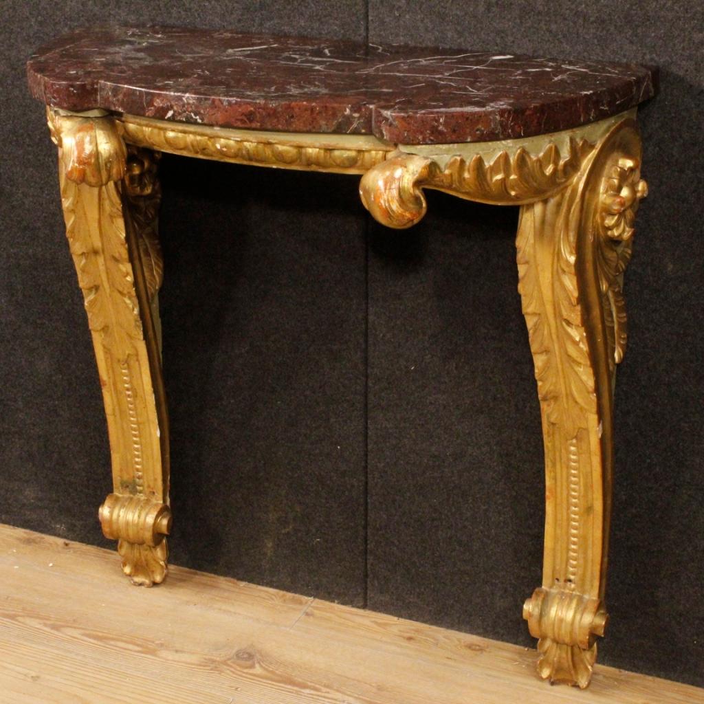 Italian console from early 20th century. Furniture in carved, lacquered and gilded wood of great quality and elegance. Console to be fixed to the wall complete with original marble with considerable weight. Marble with a thickness of 3.5 cm, of