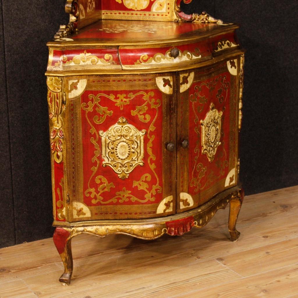 Tuscan corner cupboard from 20th century. Furniture in richly lacquered and gilded wood with chiselled and embossed decorations of great pleasure. Corner cupboard with a shelf of fabulous decoration, ideal to be placed in a living room. Cabinet with