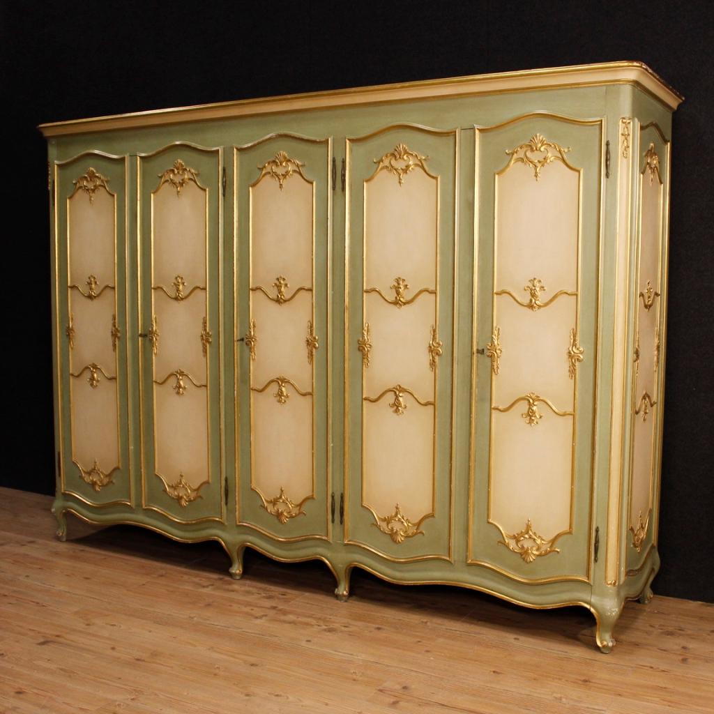 Great Venetian wardrobe from 20th century. Furniture of great measure, capacity and impact in carved, lacquered and gilt of excellent quality. Wardrobe complete with clothes hangers in the four side doors. Central door equipped with three internal