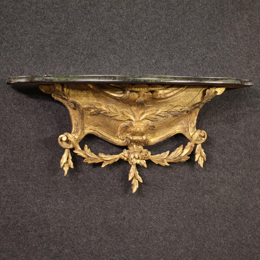 Italian console of the first half of the 20th century. Furniture of great quality and small size in carved, gilded and lacquered wood in Louis XV style. Console to be fixed to the wall with wooden top lacquered in faux marble, of discreet size and