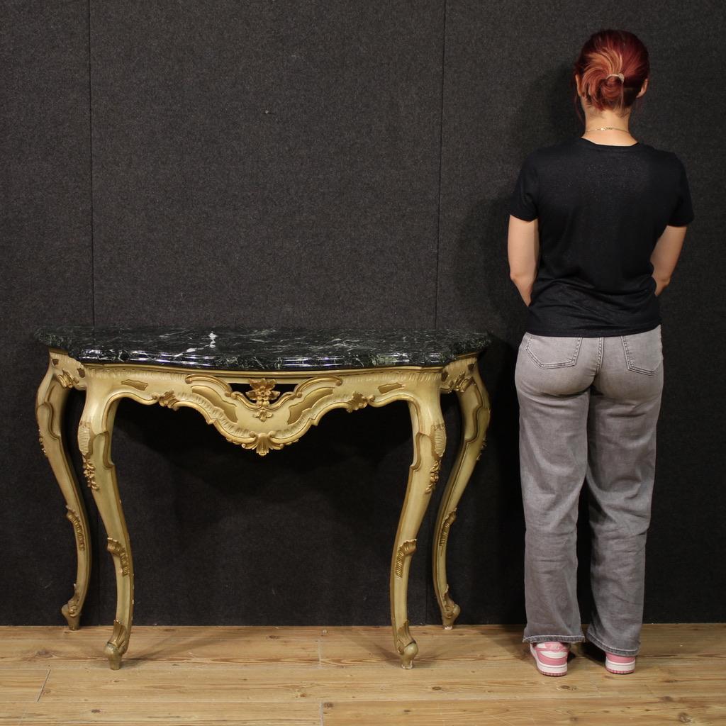 Italian console from the mid-20th century. High-legged furniture, in carved, lacquered and gilded wood (bronze tint) of beautiful line and pleasant furnishings. Original marble top of good size and service, glued to the furniture. Wall console, of