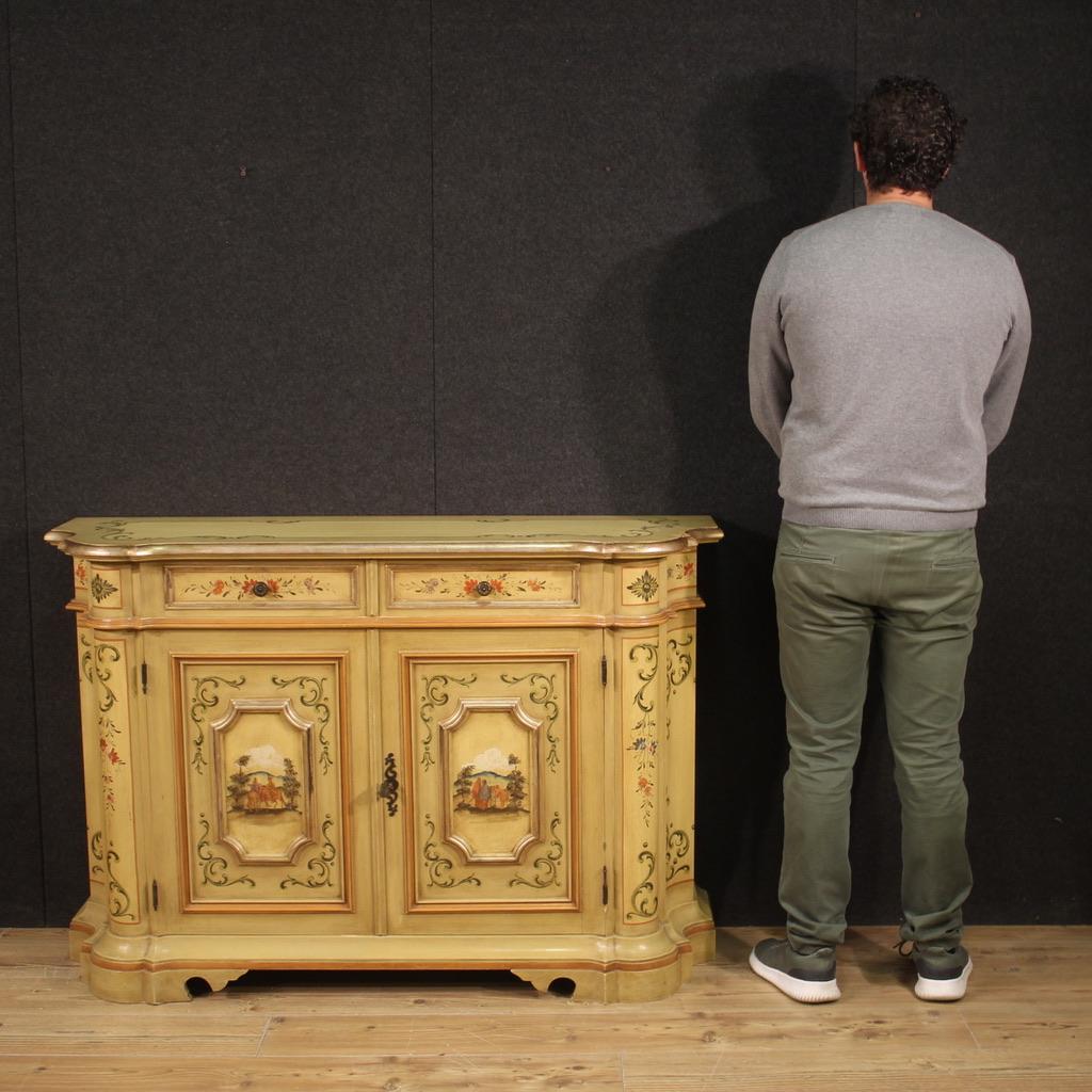 Venetian sideboard from the second half of the 20th century. Finely sculpted, lacquered, silvered and hand painted furniture with animated views and floral decorations. Sideboard of good size and proportion equipped with two parallel drawers placed