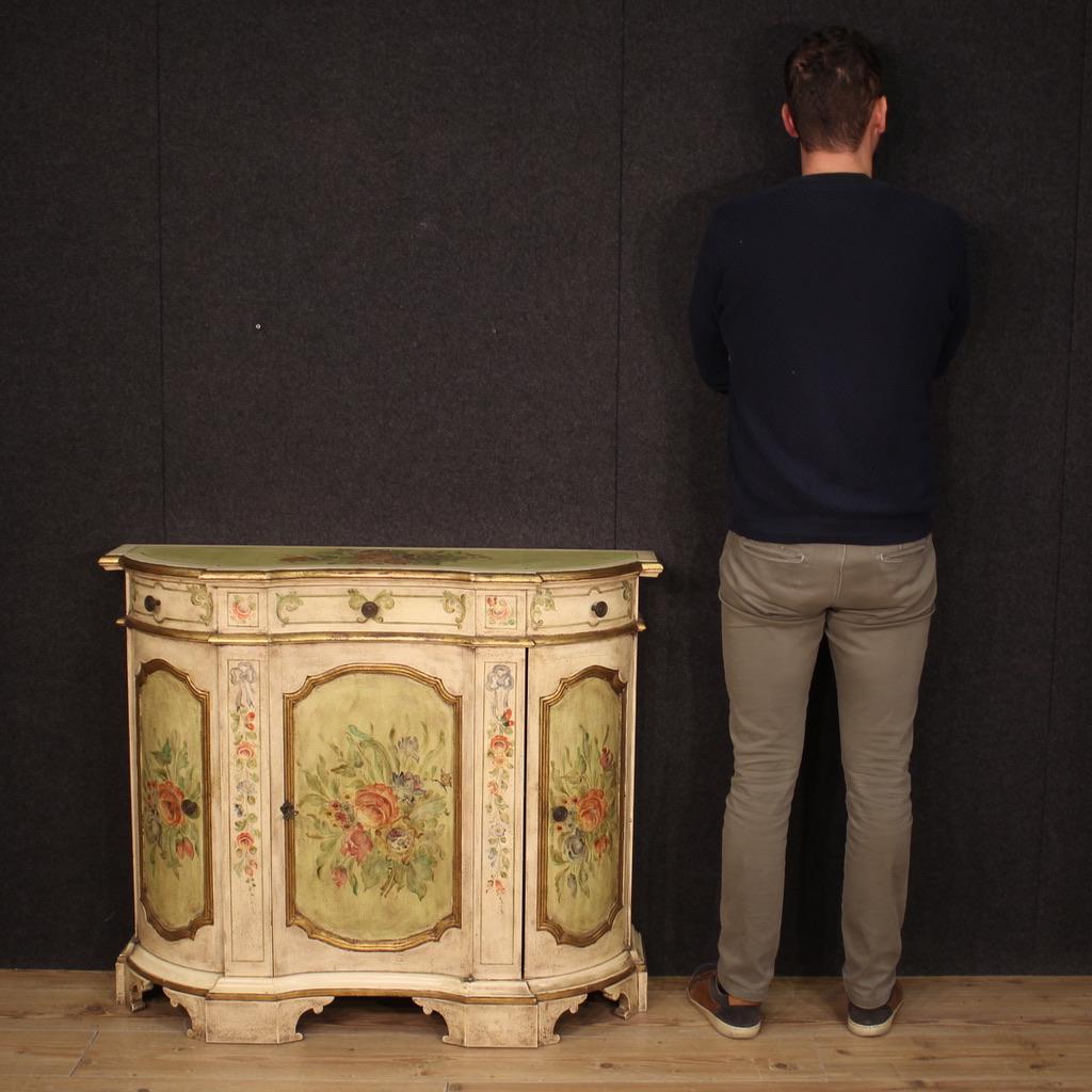 Venetian sideboard from the second half of the 20th century. Wavy and rounded furniture, in lacquered, gilded and hand-painted wood, with very pleasant floral decorations. Sideboard equipped with three doors and a central drawer of good capacity.