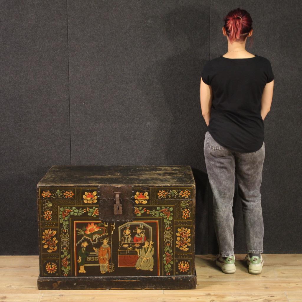 Chinese chest from the mid-20th century. Lacquered and painted wooden furniture with floral decorations and a central scene with oriental characters in an antique style of great pleasure. Beautifully sized and very capable trunk complete with two