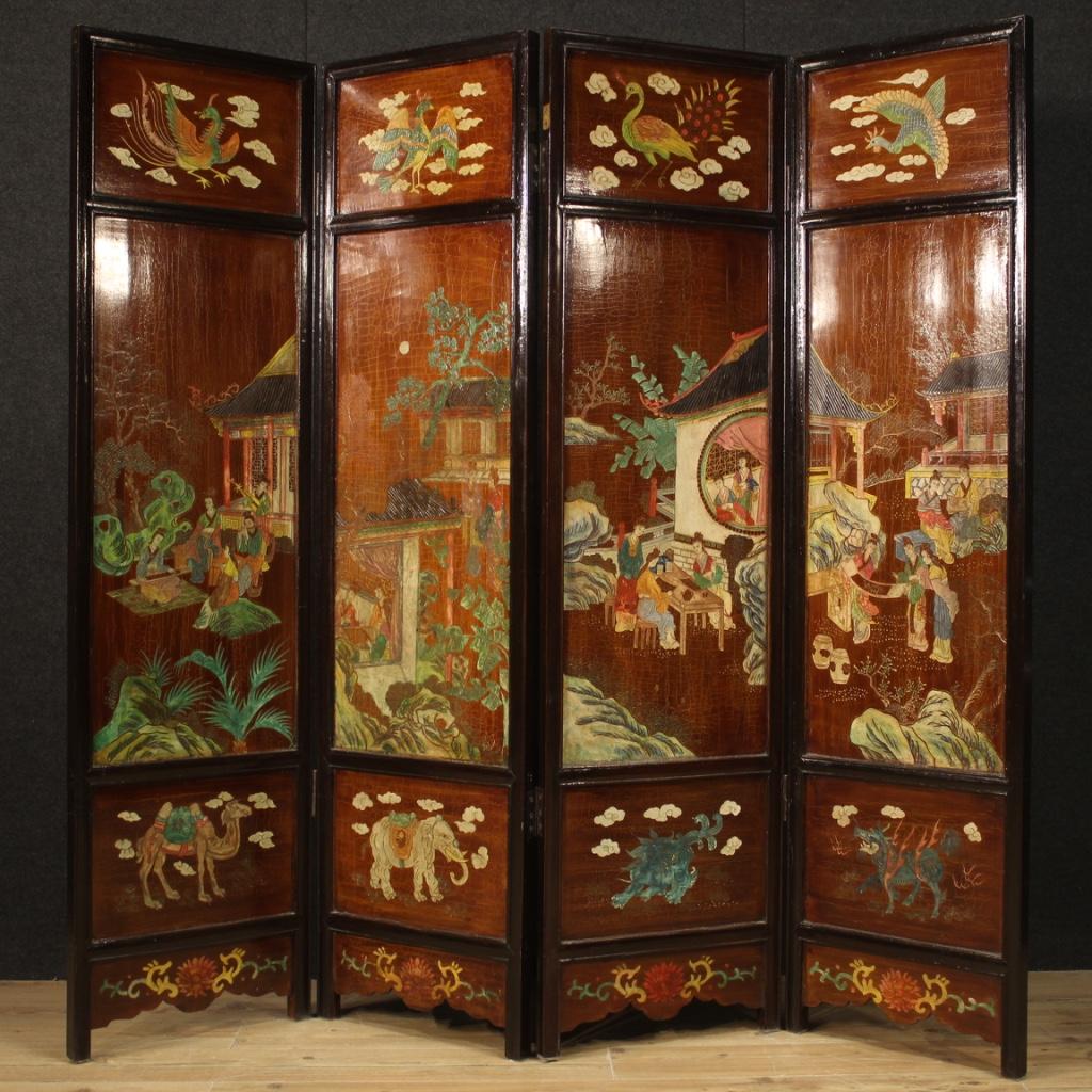 Chinese screen from 20th century. Wooden furniture composed of four lacquered panels, chiseled and painted with oriental landscapes and characters. Screen finished on both sides, adorned with animal figures and floral decorations (see photo).