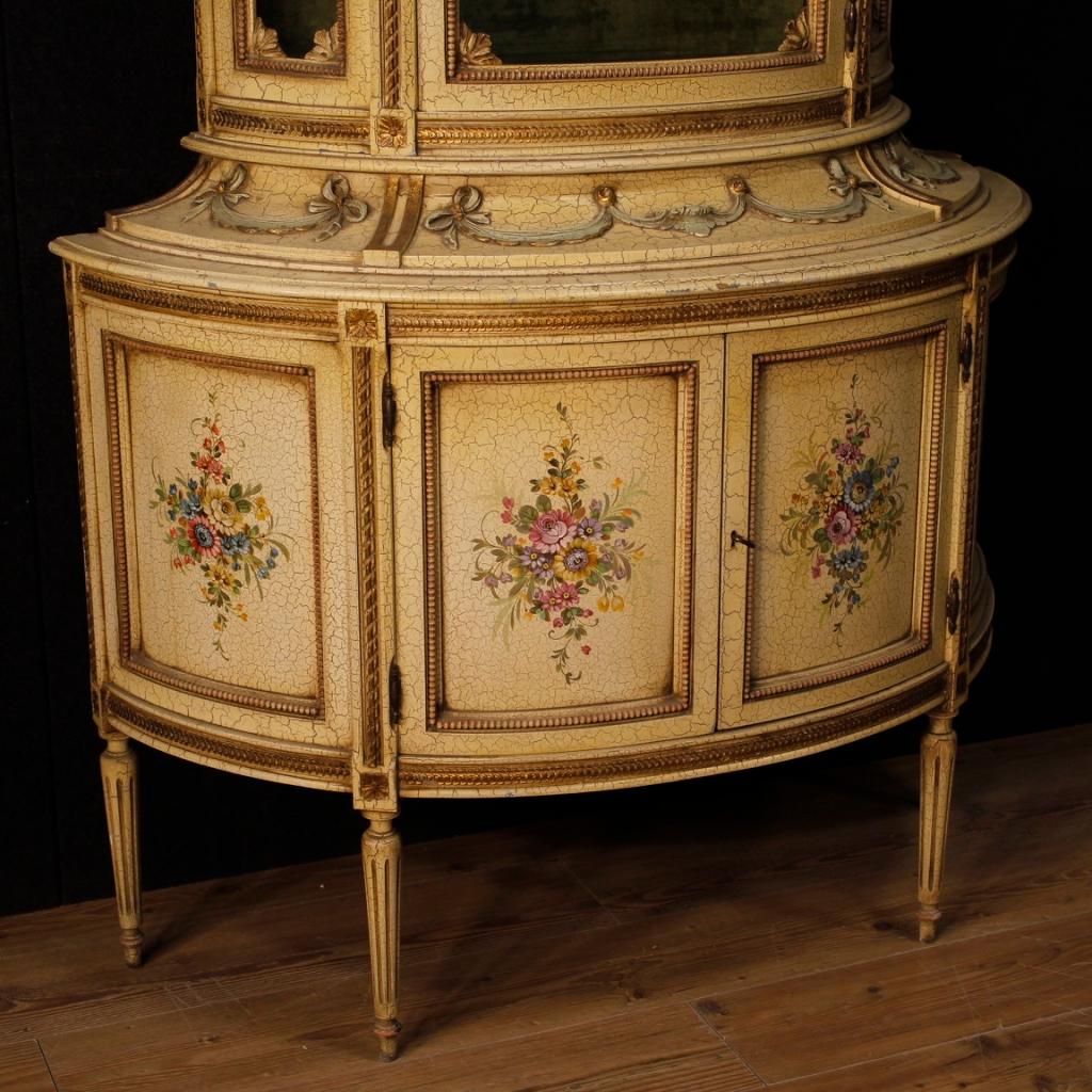 20th century Italian demilune showcase. Beautiful furniture of nice decor in Louis XVI style, in carved, lacquered and painted wood. Double body cabinet with a particular shape with two doors at the bottom, a door and a secret drawer in the upper