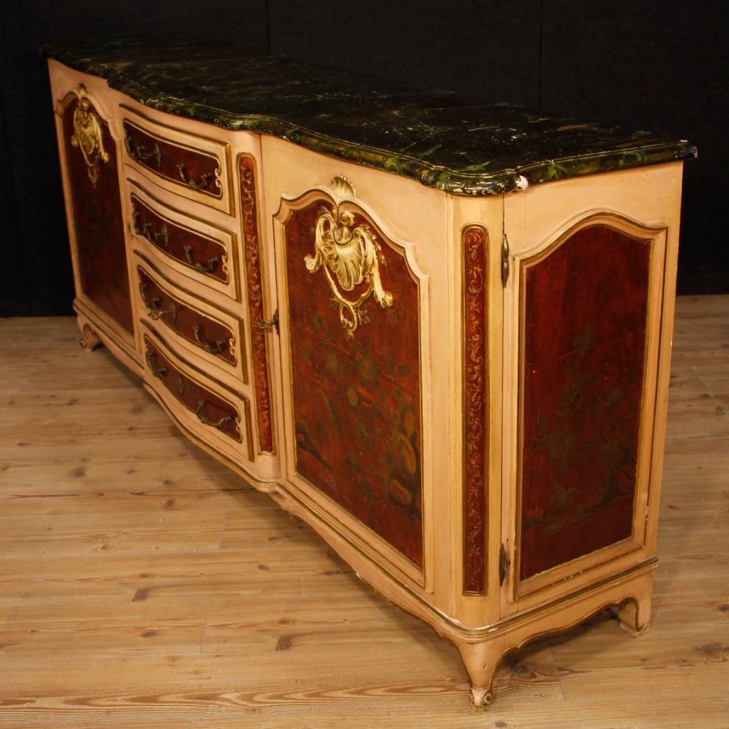 Venetian sideboard from 20th century. Painted and lacquered wooden cabinet with chinoiserie decorations of great size and charm. Sideboard with two side doors equipped with an adjustable internal shelf for compartment and four central drawers, of