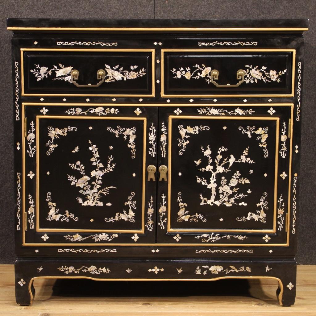 Oriental sideboard from 20th century. Furniture of beautiful line and pleasant decor in lacquered, painted wood and adorned with mother of pearl effect inserts depicting animal figures and floral decorations. Sideboard with two doors and two drawers