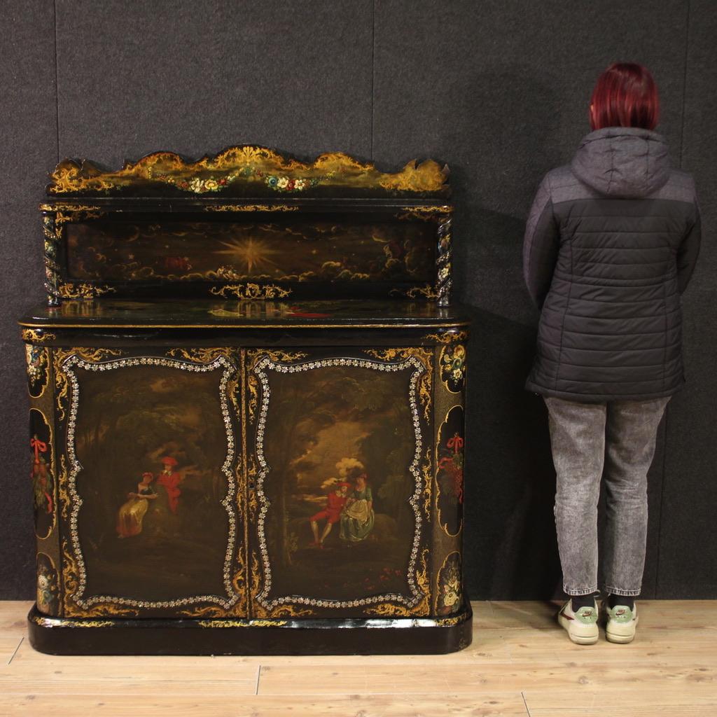 Buffet anglais de la seconde moitié du XIXe siècle. Cabinet en bois et papier mâché finement laqué et peint à la main avec de très agréables figures et décorations florales. Buffet à deux portes avec une section surélevée à colonnes tournées et une