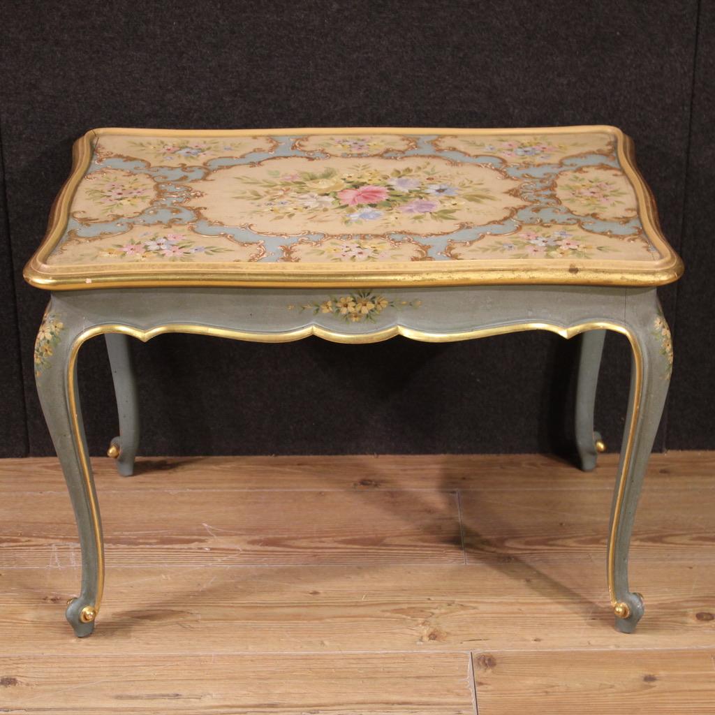 Italian coffee table from the mid 20th century. Sculpted, lacquered and gilded furniture in Venetian style with very pleasant hand-painted floral decorations. Coffee table supported by four solid legs with curled feet (see photo). Wooden top in