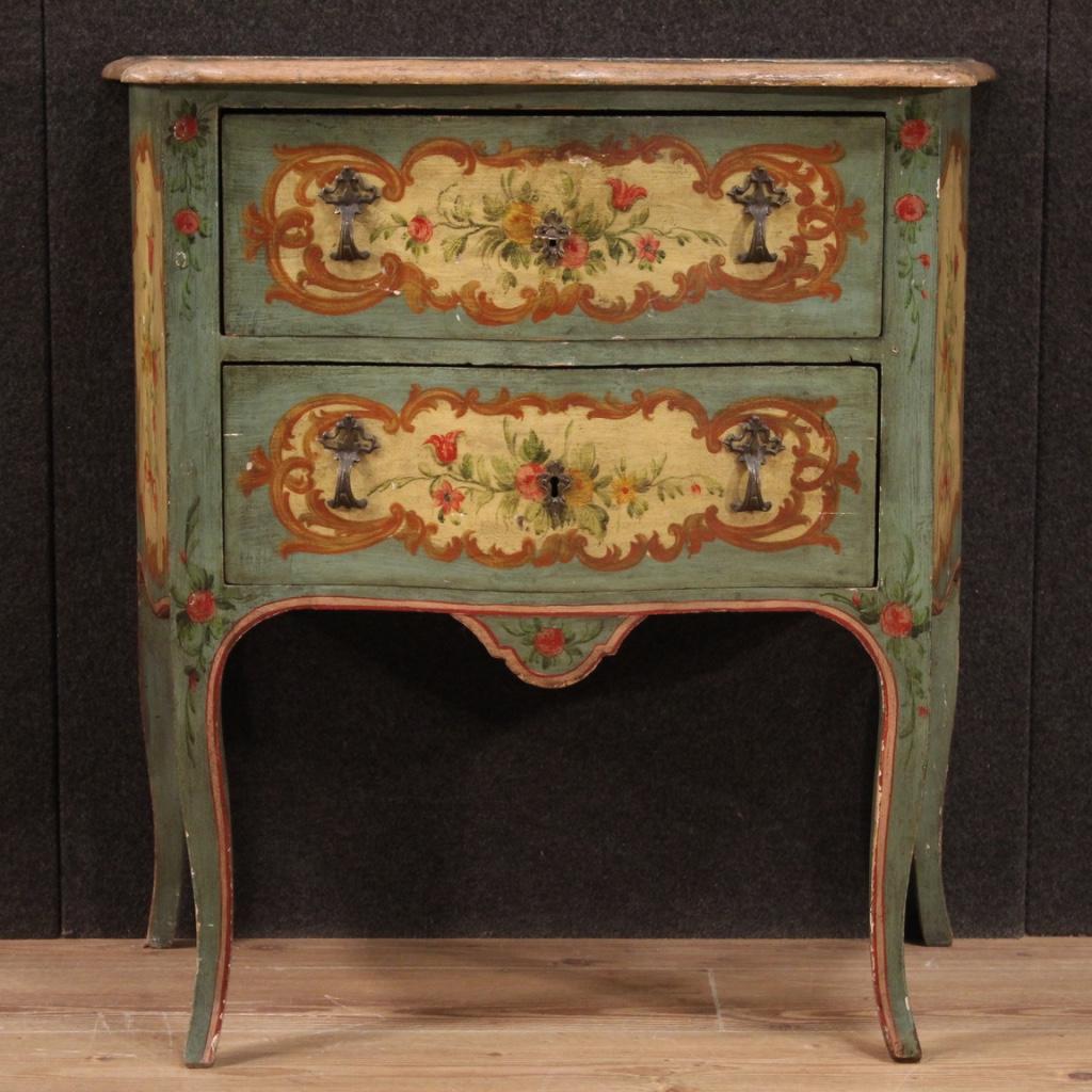 Small Venetian commode from the mid-20th century. Furniture in carved, lacquered and hand painted wood with very pleasant floral decorations. Commode equipped with two front drawers of good capacity and wooden top in character also lacquered and