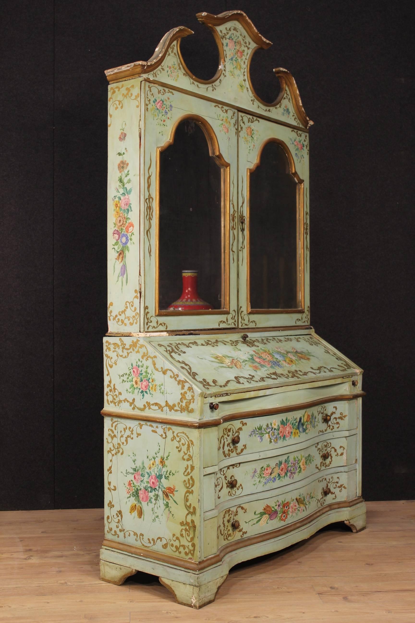 Venetian trumeau from the early 20th century. Furniture in ornately carved, lacquered and painted wood with floral decorations. Venetian trumeau built in two bodies. Lower half with three external drawers, inside with two drawers, one door and a