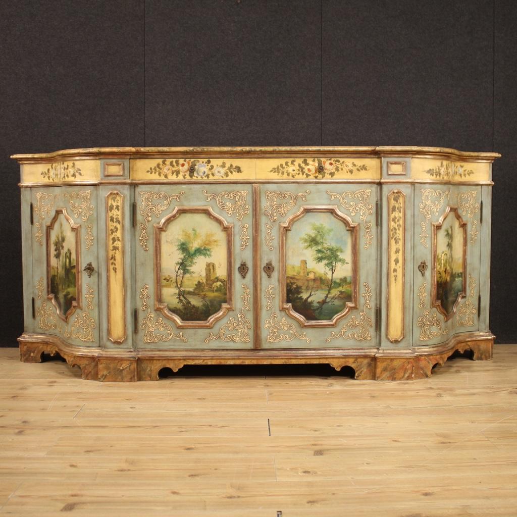 Venetian sideboard from the mid-20th century. Furniture in carved, lacquered, gilded and hand painted wood of great quality and fabulous furnishings. Sideboard with four doors and two drawers of excellent capacity. Wooden top in faux marble