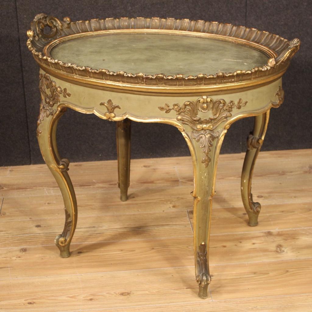Venetian tray table from the 20th century. Furniture in carved, lacquered and gilded wood of excellent quality. Coffee table supported by four solid legs, chiseled and adorned with curled feet. Wooden tray top (not divisible from the base) with side