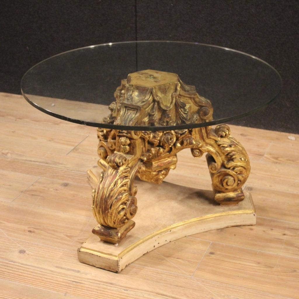 Round Italian coffee table from 20th century. Furniture composed of two distinct elements, lacquered and gilded wooden base in antique style and modern glass top, pleasantly furnished. Solid base that attaches to the top with a central metal pin