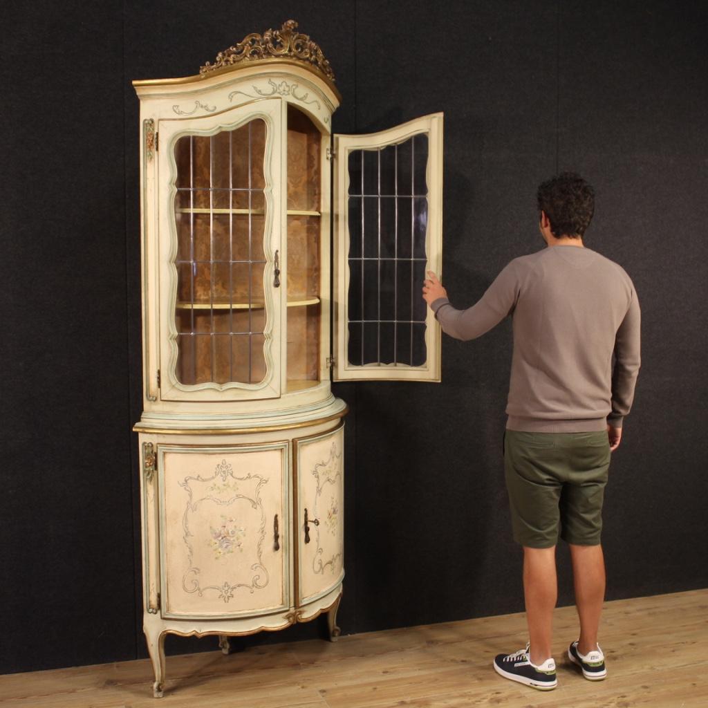 Armario esquinero veneciano del siglo XX. Muebles de gran tamaño e impacto en madera tallada, lacada, dorada y pintada a mano con decoraciones florales muy agradables. Armario esquinero de doble cuerpo apoyado sobre tres patas talladas con pies