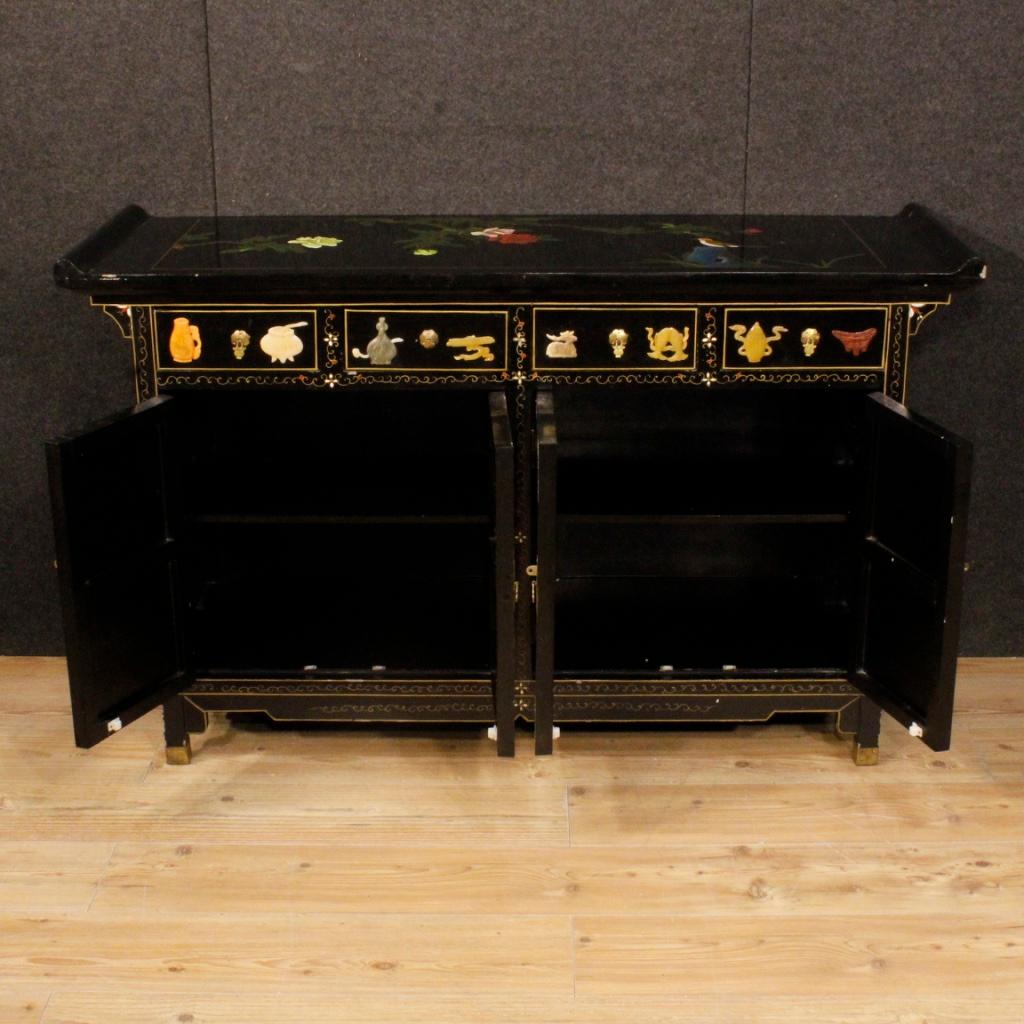 Chinese sideboard from 20th century. Furniture in carved, lacquered, painted wood and adorned with relief decorations in soapstone. High-quality sideboard of good service, equipped with four drawers and four doors. A drawer and a door have a lack of