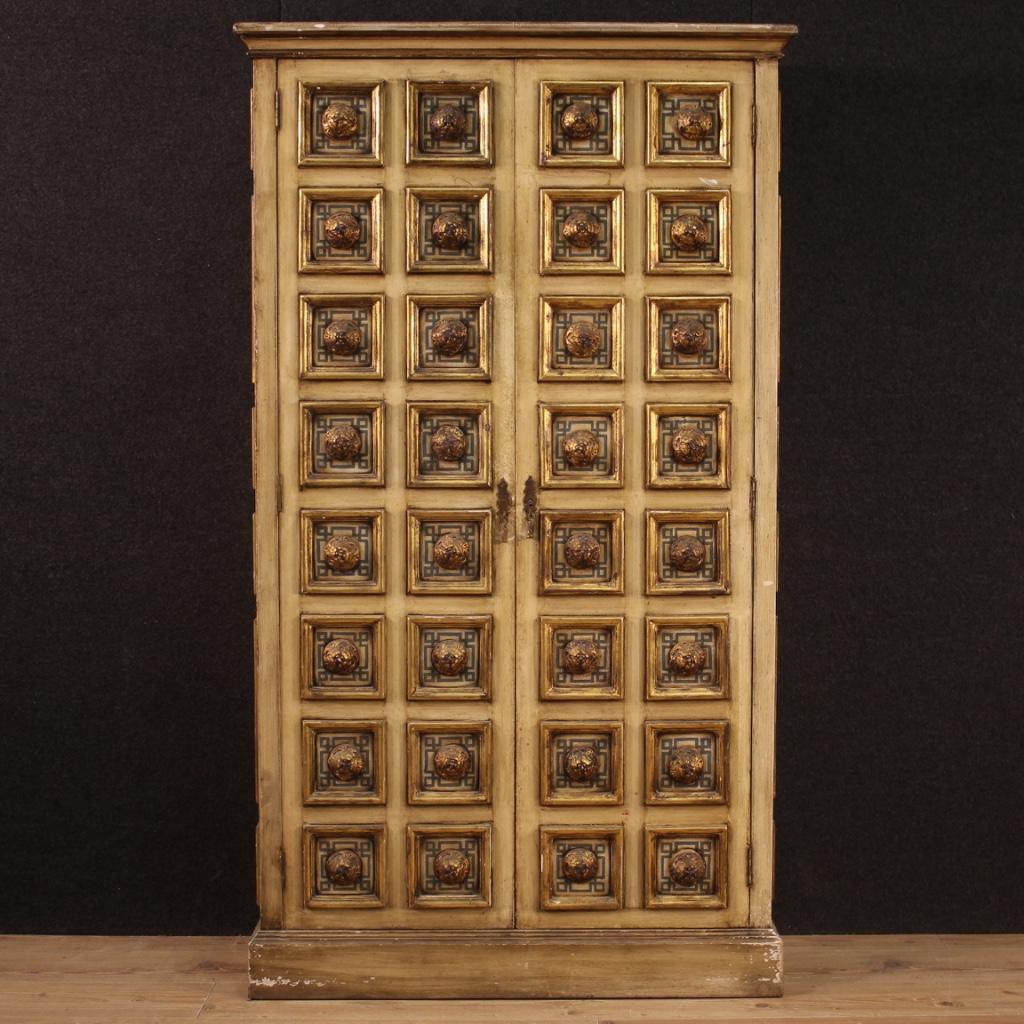 20th century Spanish hall cabinet. Furniture built in a single non-divisible block of wood and plaster richly carved, lacquered, gilded and hand painted with geometric decorations. Two-door wardrobe complete with working key, internally fitted with