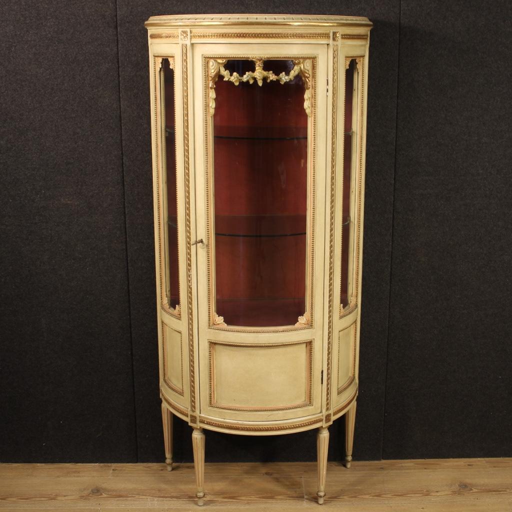 Italian showcase from 20th century. Pleasantly demilune furniture carved, gilded, painted and lacquered wood. One-door showcase equipped with a working key and three internal shelves of good service. Cabinet of excellent proportion, it can be easily