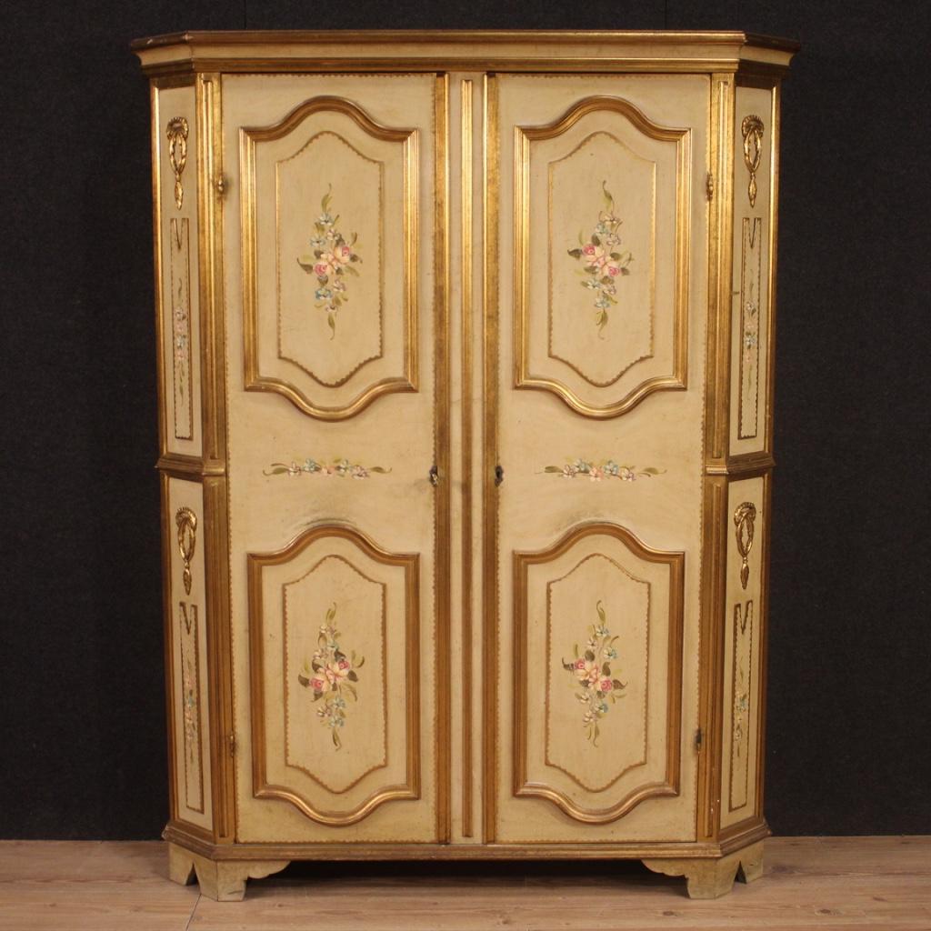 Italian wardrobe from 20th century. Furniture in carved, lacquered, gilded and hand painted wood with very pleasant floral decorations. Entrance cabinet with two doors, internally equipped with four chiseled metal hangers placed frontally on a