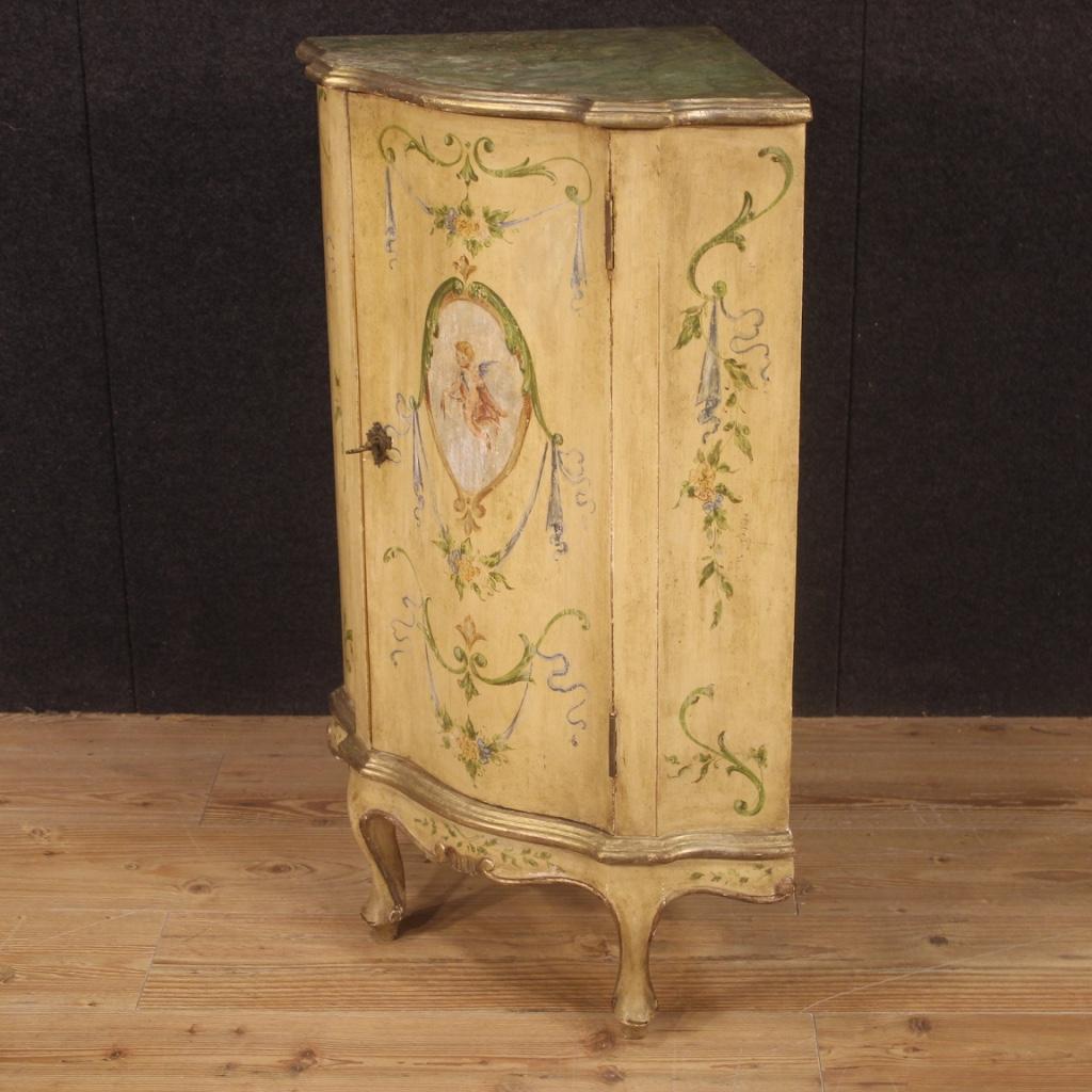 Small Venetian corner cupboard from the 20th century. Furniture in lacquered, gilded and hand painted wood with floral decorations and central angel. Corner cabinet with a door complete with key, fitted inside with a fixed shelf plus a floor-level