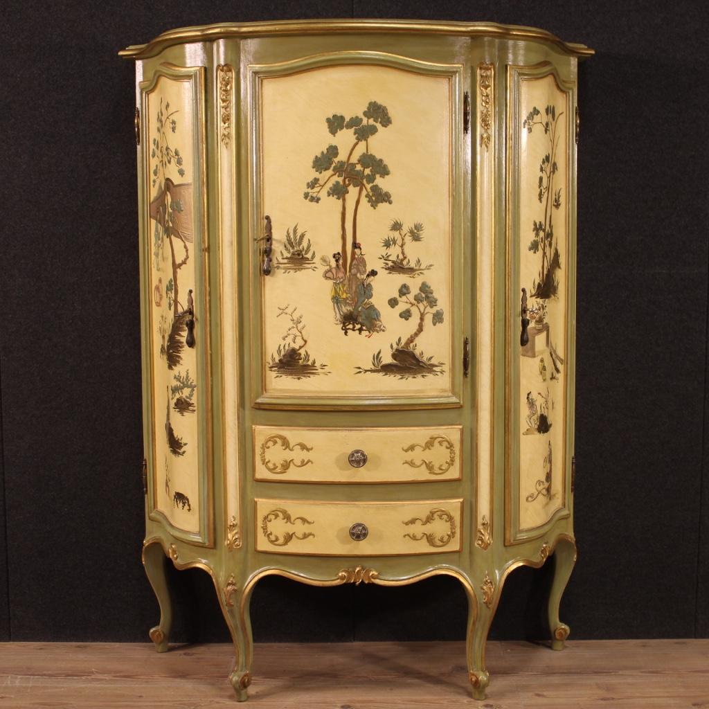 Venetian cupboard from 20th century. Moved and rounded furniture richly gilded, lacquered and painted with chinoiserie decorations of excellent quality. Cabinet equipped with two side doors that offer 4 shelves inside. Central door complete with two