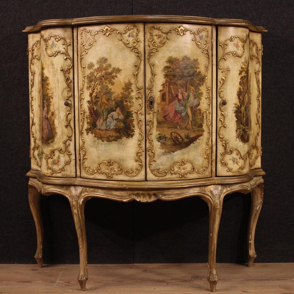 Venetian sideboard from the mid-20th century. Moved and rounded furniture of exceptional quality in lacquered, gilded and hand painted wood. Four-door sideboard of good capacity and service. Doors and top adorned with landscapes with