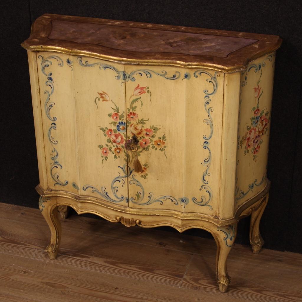 Gracious Venetian sideboard from the 20th century. Furniture of beautiful line and excellent proportion in lacquered, gilded and hand painted wood with floral decorations. Sideboard with two doors, complete with working key and an internal shelf, of