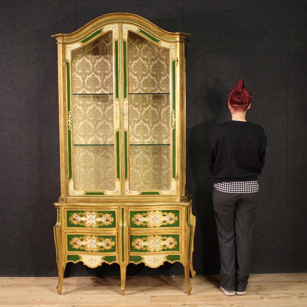 Florentine display cabinet from the mid-20th century. Richly lacquered, gilded and hand-painted with floral decorations of great pleasure. Double body display cabinet equipped with a chest of drawers with 4 drawers in the lower part. Upper body with
