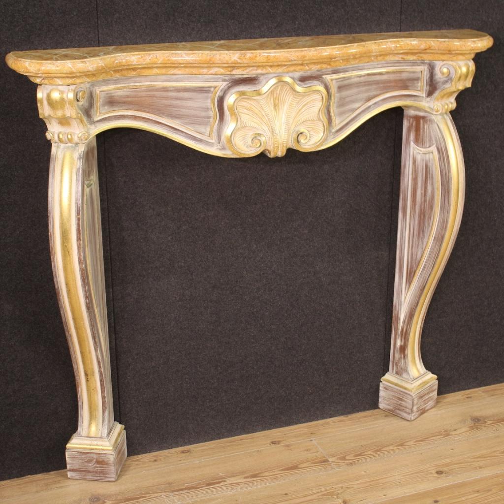 Italian fireplace from the second half of the 20th century. Front fireplace decoration in carved, lacquered and gilded wood of beautiful line and quality. Finely lacquered imitation marble top (see photo) of discreet size and service. Furniture