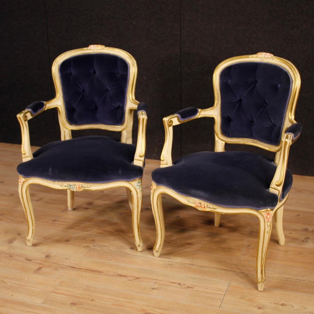 Pair of Italian armchairs from 20th century. Furniture in carved, lacquered, gilded and beautifully painted wood pleasantly decorated. Armchairs upholstered in blue velvet with some small signs of wear. Furniture of excellent proportion, it can be