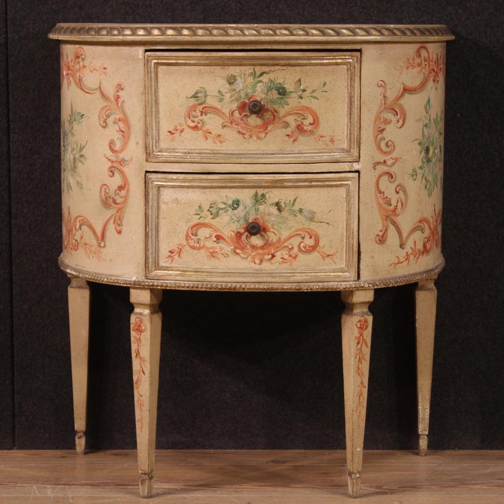 Small Italian commode from the 20th century. Half-moon cabinet in carved, lacquered, silvered and painted wood with floral decorations in the Louis XVI style. Dresser of excellent proportions, it can be easily placed in different parts of the house,