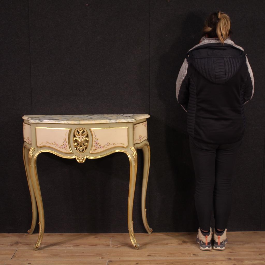 Italian console from the mid-20th century. Furniture with beautiful lines and pleasant furnishings in carved, lacquered, gilded and hand-painted wood with very pleasant floral decorations. High leg console adorned with curled feet (see photo) of
