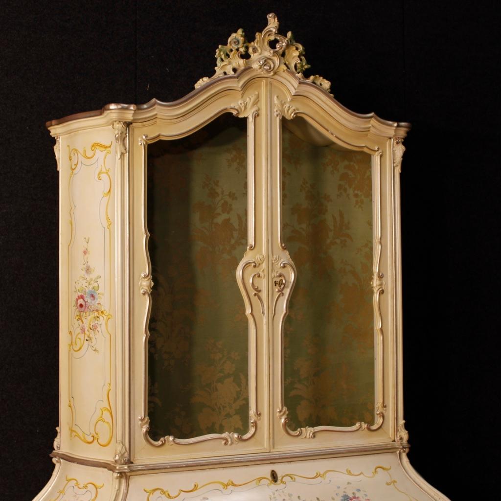 Venetian trumeau from the mid-20th century. Furniture in carved, lacquered, silvered and painted wood with floral decorations of great pleasure. Double body trumeau equipped with two doors in the lower body (inside complete with a shelf) and bureau.