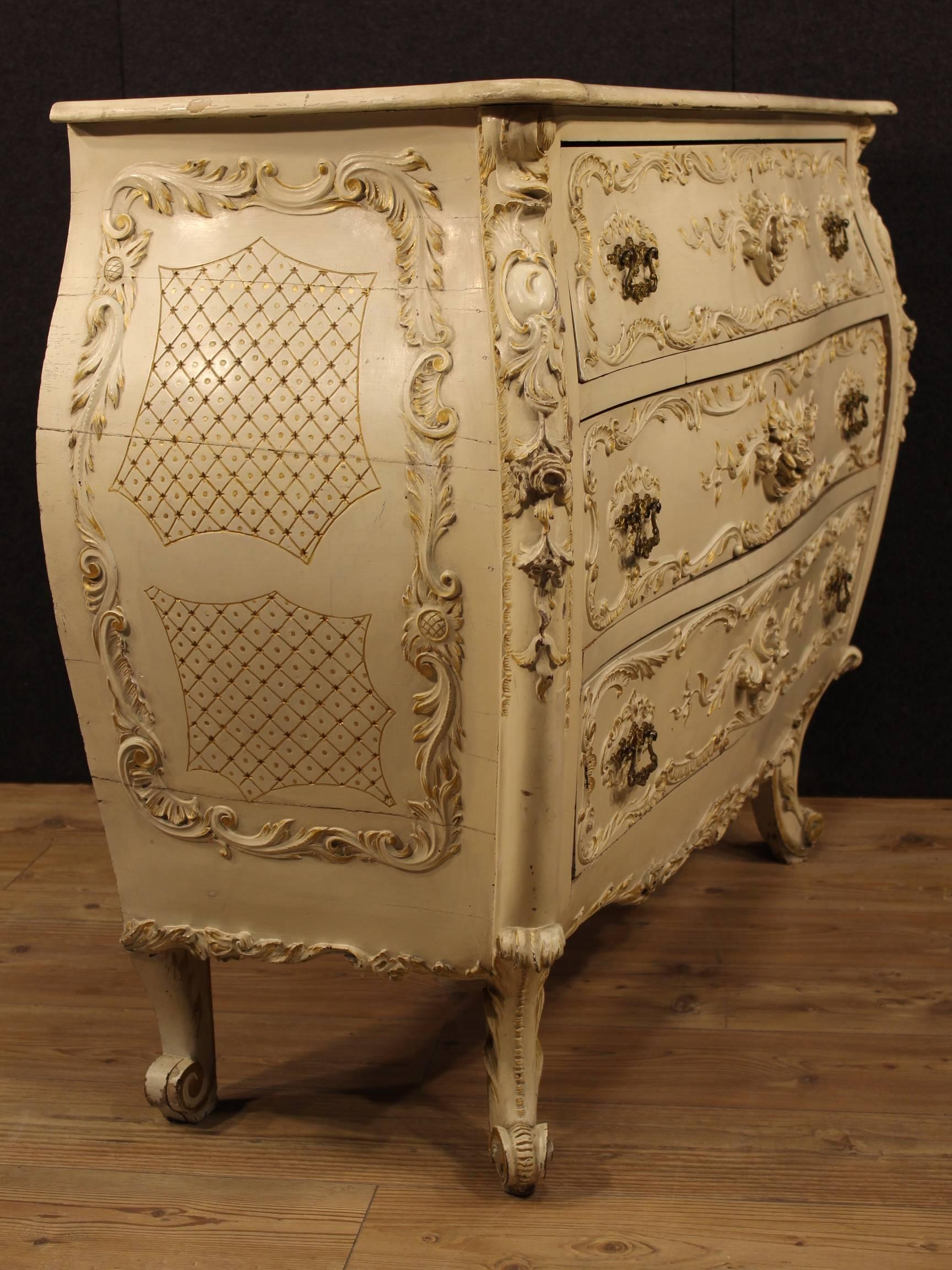 Great Italian chest of drawers of the early 20th century. Furniture made by richly carved and lacquered wood with floral decorations in relief. Dresser with urn pleasantly decorated with gilding. Furniture rounded and curved of special construction,