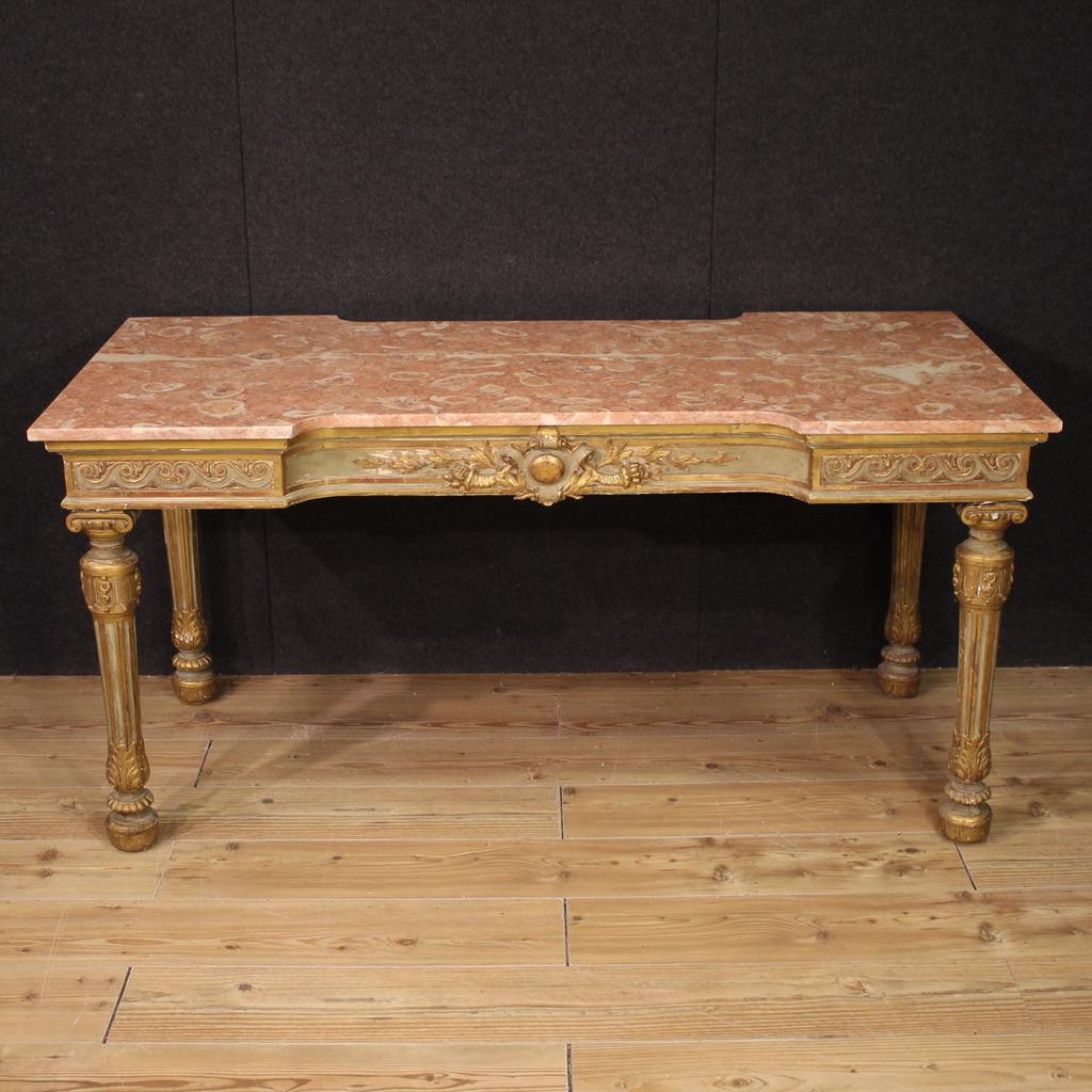 Elégante console italienne du milieu du 20e siècle. Bois finement sculpté, laqué et doré dans le style néoclassique Louis XVI, d'excellente qualité. Cette grande table de console centrale est dotée d'un plateau en marbre d'origine, en bon état.